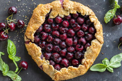 Baked Cherry Galette with basil and cherries next to it.