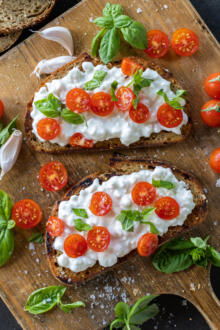 Cottage Cheese Toasts on a board with basil.