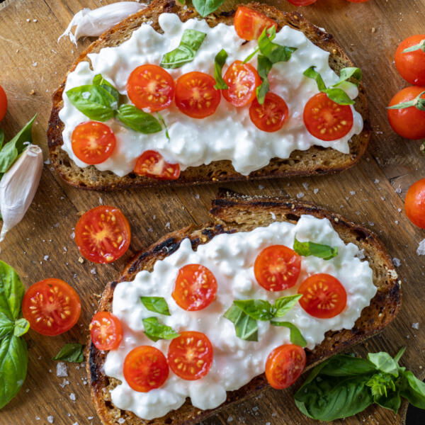 Cottage Cheese Toasts on a board with basil.