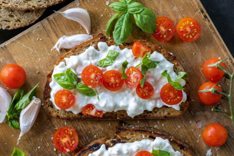 Cottage Cheese Toast with tomatoes on a side.