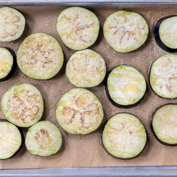 Seasoned eggplant on a baking sheet.