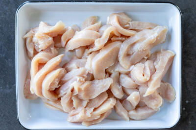Sliced chicken on a sheet pan.