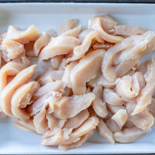Sliced chicken on a sheet pan.