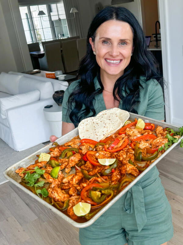 Natalya with Chicken Fajitas on a sheet pan with tortillas.