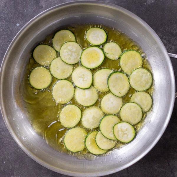 Fried sliced zucchini in a pan.