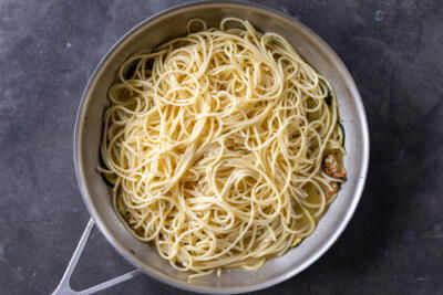 Pasta added to zucchini with sauce.