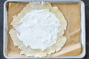 Rolled out dough with goat cheese on it.