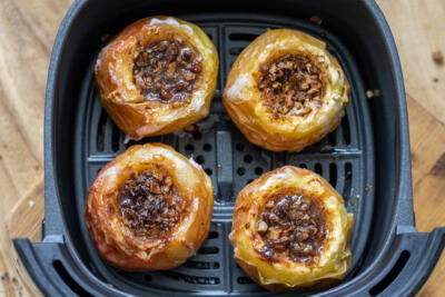 Air fryer basket with apples.
