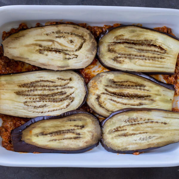 Slices of eggplant in a pan.