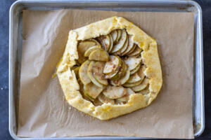 Pear Galette on a baking sheet with edges brushed with egg wash.