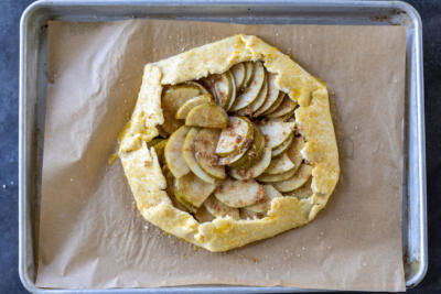 Pear Galette on a baking sheet with edges brushed with egg wash.