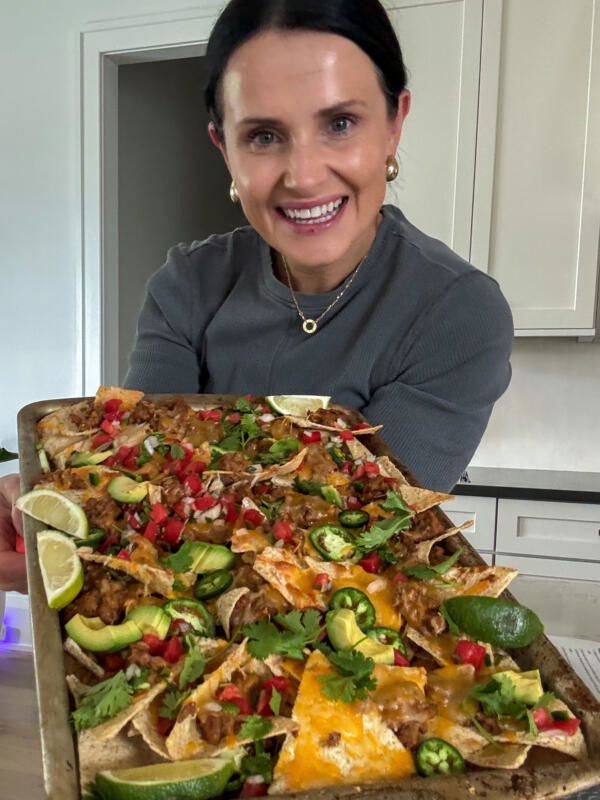 Natalya with sheetpan nachos in had.