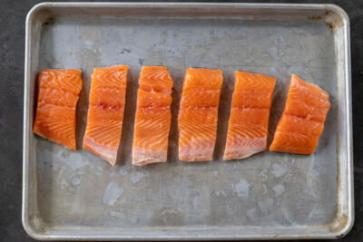 Sliced up salmon on a baking sheet