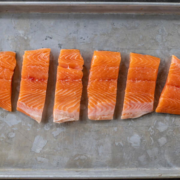 Sliced up salmon on a baking sheet