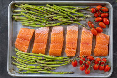 Salmon with veggies on a baking sheet.
