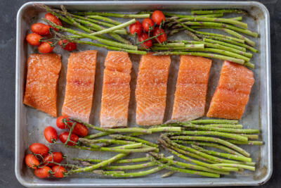 Seasoned salmon and veggies on a tray.