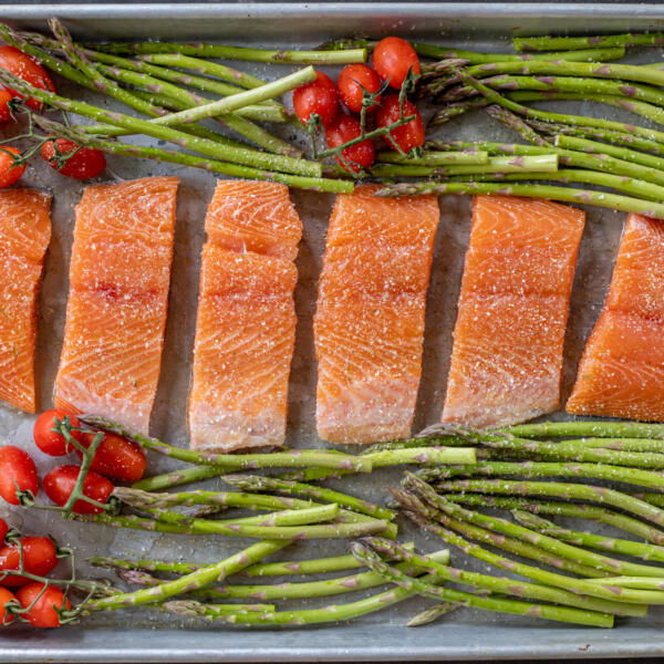 Seasoned salmon and veggies on a tray.