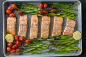 Baked salmon and veggies on a tray.
