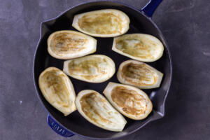 Scooped out eggplant in a baking pan.