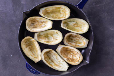 Scooped out eggplant in a baking pan.