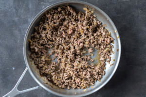 Ground beef in a pan with onion.