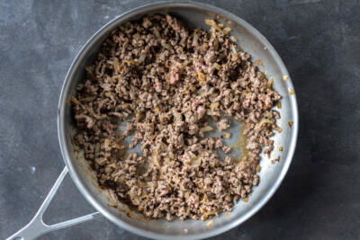 Ground beef in a pan with onion.