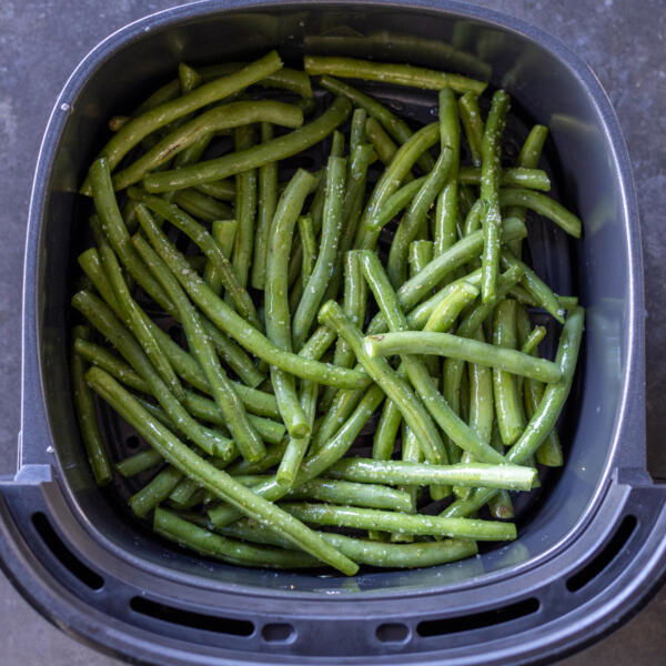 Green beans in an air fryer basket.