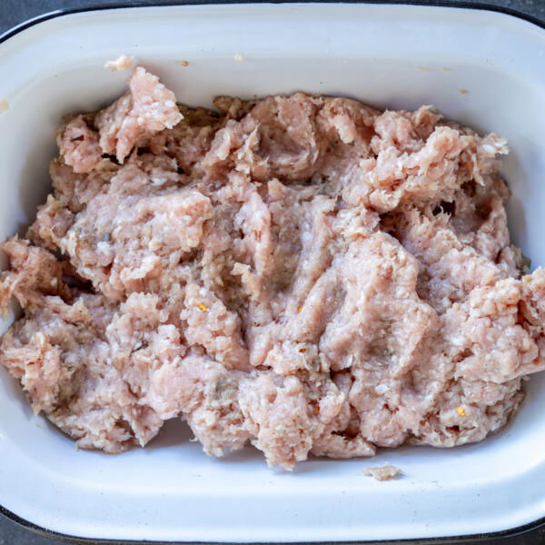 Pork with seasoning in a bowl.