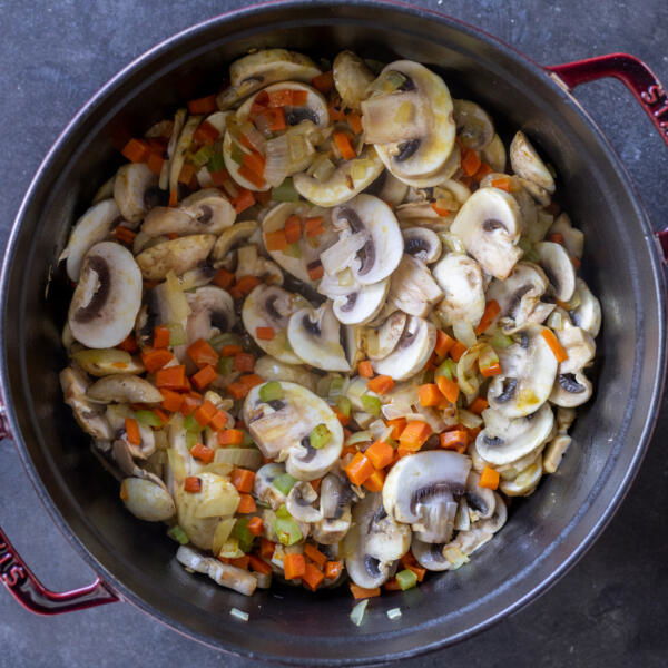 A pot with veggies with mushrooms.
