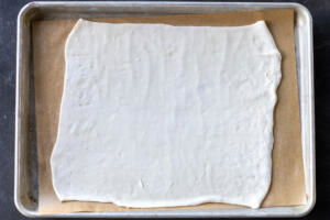 Rolled out puff pastry on a lined baking sheet.