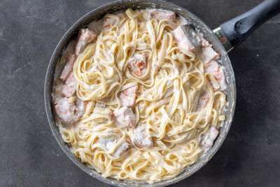 Salmon Alfredo in a pan.