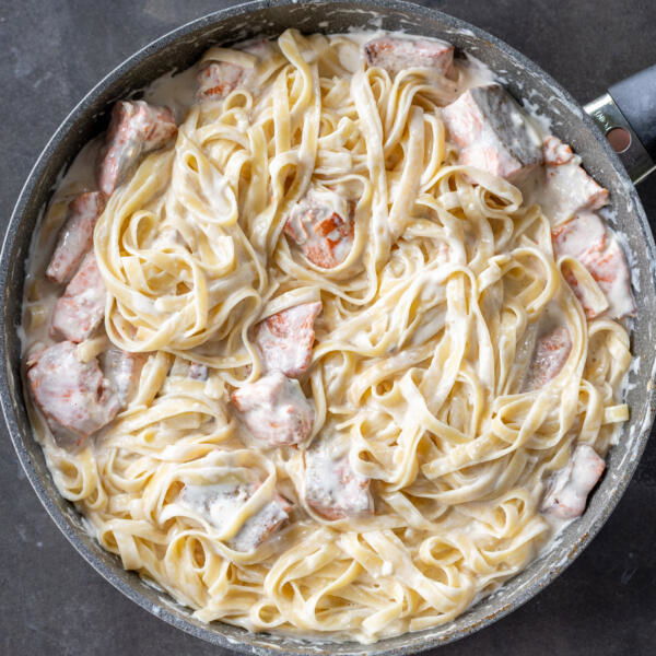 Salmon Alfredo in a pan.