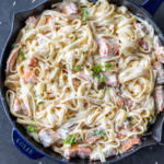 Pan with Salmon Alfredo with herbs on top.