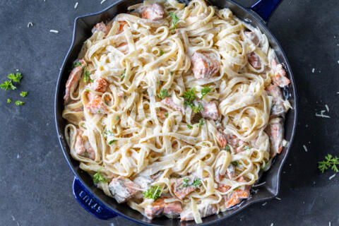 Pan with Salmon Alfredo with herbs on top.