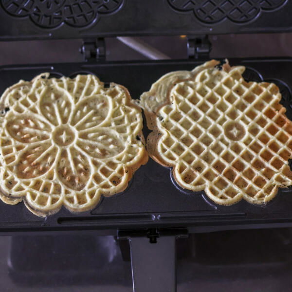 Pizzelles on a maker, cooked.