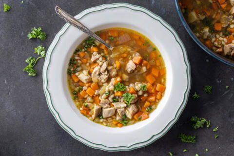 Chicken Barley Soup in a bowl with a spoon.