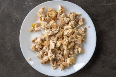 Cut up chicken in on a plate.