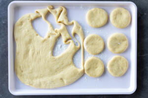 Rolled out brioche donuts dough with cut outs.