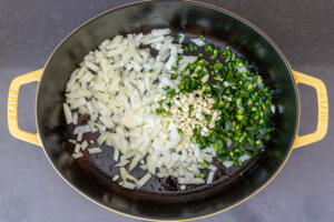 A pot with veggies sautéing.