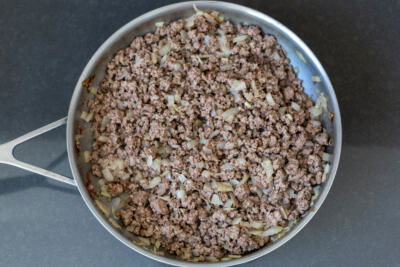 Meat and onion frying in a pan.