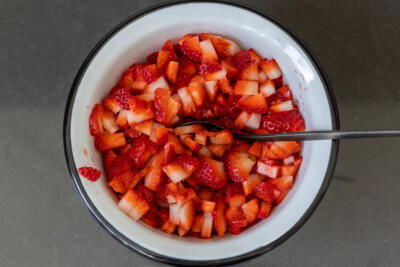 Cut up strawberries in a bowl.