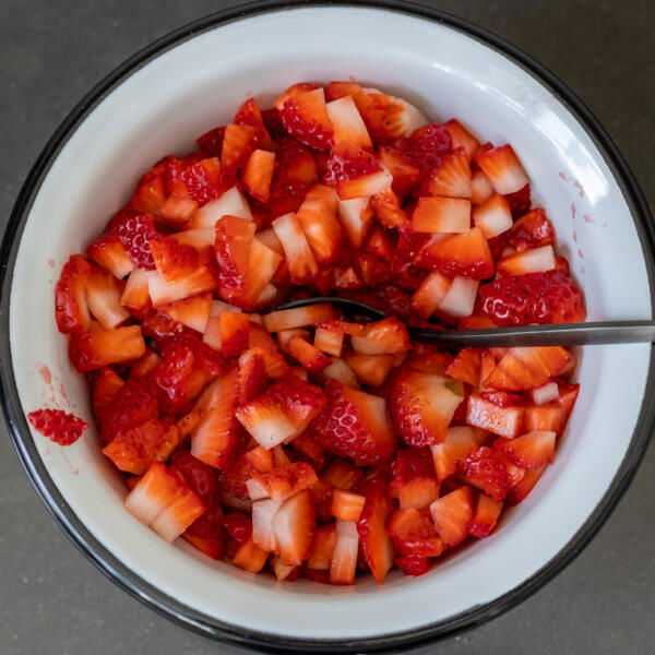 Cut up strawberries in a bowl.