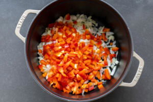 Chopped up veggies in a pot with oil cooking.