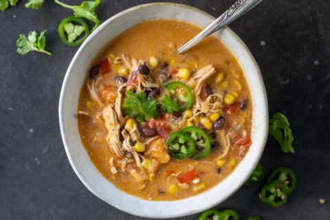 A bowl with Creamy Chicken Taco Soup and toppings.