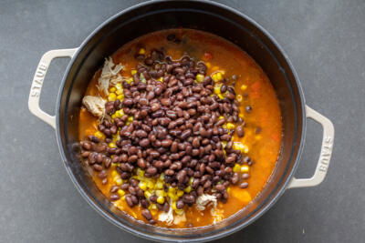 Beans and corn in a pot with remainder ingredients.