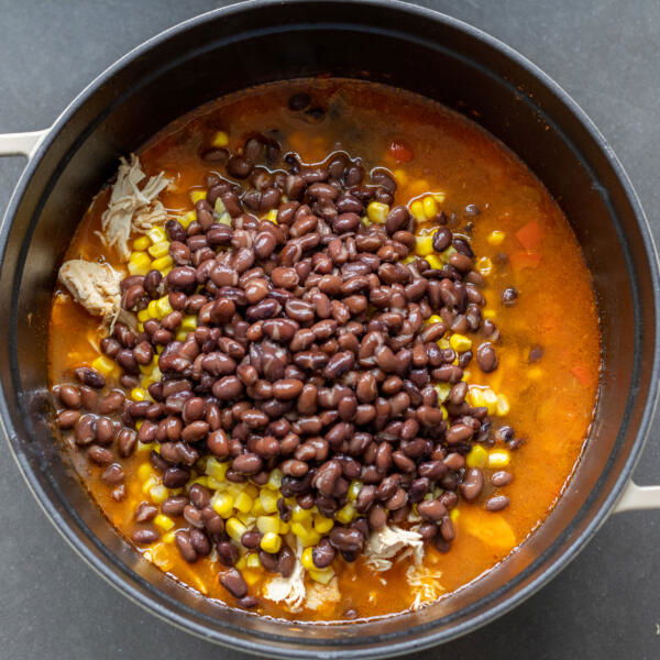 Beans and corn in a pot with remainder ingredients.