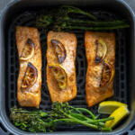 Air fryer basket with cooked salmon.