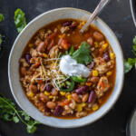 A bowl of chili with toppings.