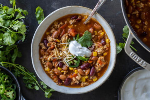 A bowl of chili with toppings.