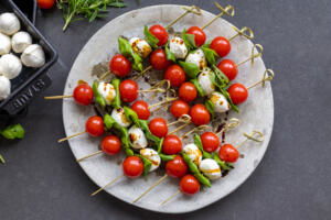 Skewer with tomato basil and mozzarella and oil with balsamic on top.